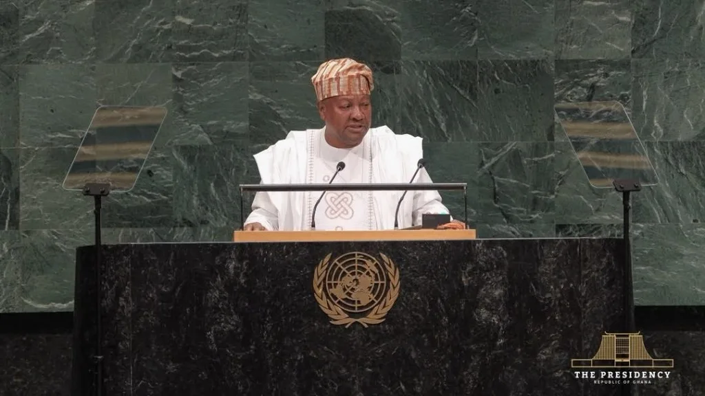 John Dramani Mahama, in white with a kente cap, speaking at the General Assembly rostrum